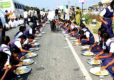 Schoolchildren partake in mid-road feast