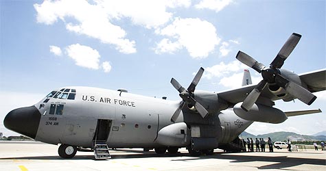 U.S. military personnel stand near a C130 aircraft
