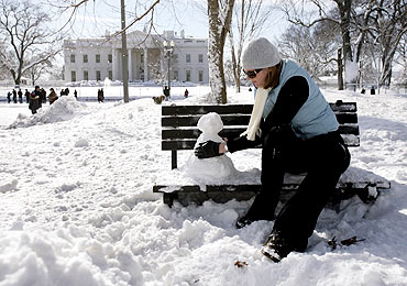 Emily Eelman makes a snowman in front of the White House in Washington