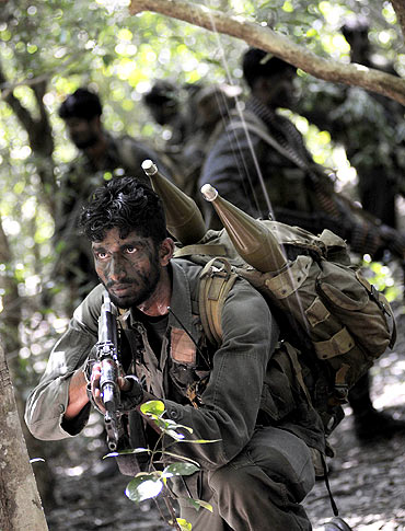 A file photo shows Sri Lankan soldier keeps watch during a patrol in the jungle in the Puthukkudiyirippu area