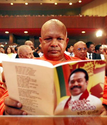 A Buddhist monk reads Sri Lanka President Mahinda Rajapaksa's election manifesto in the run-up to the presidential elections
