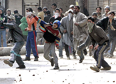 Kashmiri demonstrators throw stones and pieces of bricks towards policemen during a protest in Srinagar