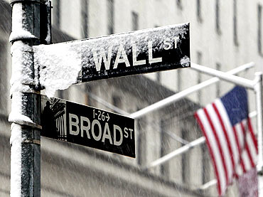 Snow covers a street sign at the corner of Wall St. and Broad St. in New York's financial district