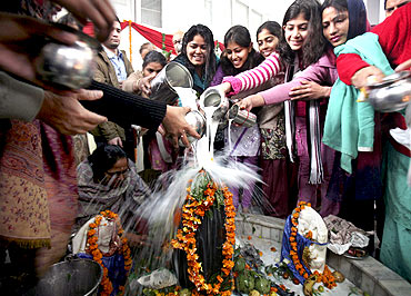 Women pour milk over a Shivling during the Mahashivratri festival in Chandigarh