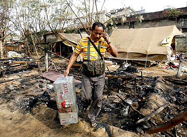 A policeman carries his colleague's belongings at a police camp that was attacked by Maoist rebels