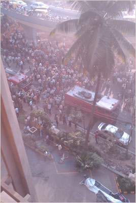 People gather outside the Carlton Towers in Bengaluru