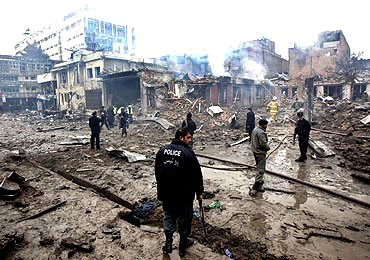 An Afghan policeman stands at the site of a blast in Kabul on Friday
