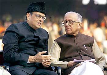 Former Indian prime minister V P Singh (L) speaks to veteran Marxist leader Jyoti Basu, after his retirement as chief minister in 2000