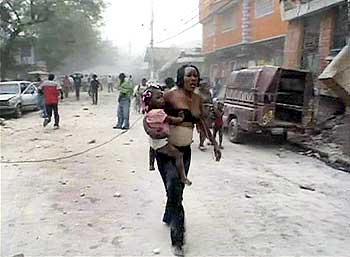 A woman carries a child after an earthquake in Port-au-Prince.