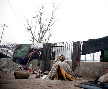 A homeless woman sits near a main road in New Delhi.