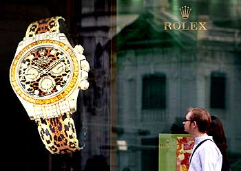 Foreign visitors walk past a watch brand advertisement at the Shinsegae department store in Seoul