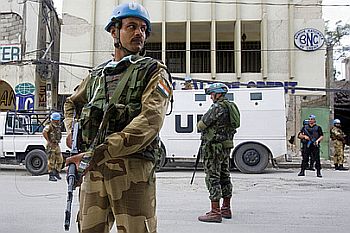 An officer from the Indian Formed Police Unit (FPU), working with Brazilian UN peacekeepers, helps to secure the perimeter of a bank in downtown Port-au-Prince