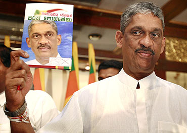 Presidential candidate Sarath Fonseka holds up a copy of his election manifesto