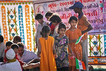 Harilal Kapdi distributes flags and biscuits to children