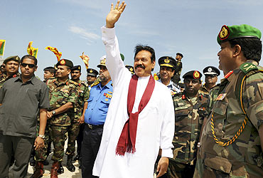 Rajapaksa waves during a photo opportunity with high-ranking military officials after unveiling a monument for fallen Sri Lankan soldiers