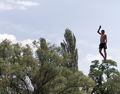 A man jumps into the cool water of the Dnipro river in Kiev. Ukraine has been experiencing very hot days this season.