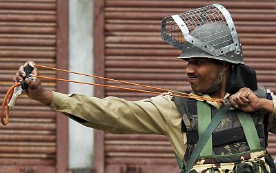 A policeman uses a sling shot during a Kashmiri protest against New Delhi's rule in the troubled Himalayan region of Kashmir, in Srinagar