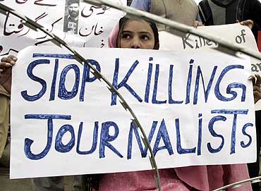 A man holds a placard during a protest against the killing of a journalist in Swat Valley