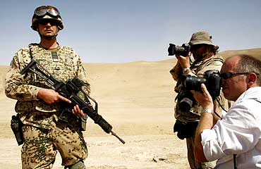 Photographers take pictures of an ISAF team during a drill near Kabul