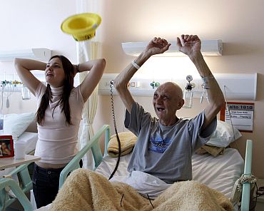 Brazilian patient Jorge Cocer and his daughter Carolina react during their national soccer team's 2010 World Cup Group G soccer match against Portugal, at the Cancer Institute Hospital in Sao Paulo.