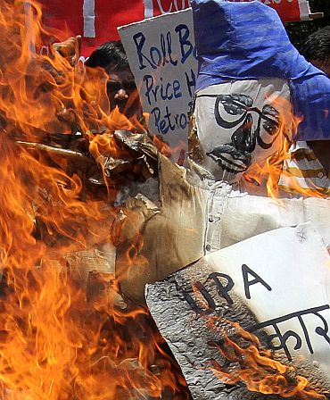Activists from the Socialist Unity Centre of India burn an effigy of Prime Minister Manmohan Singh