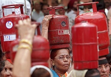 BJP activists hold LPG cylinders during a protest in New Delhi