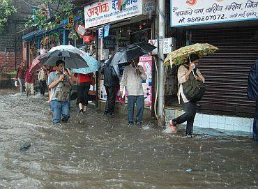 People wade through a waterlogged street near Dadar
