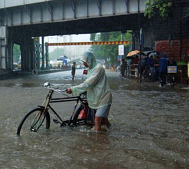 A cyclist finds his way through a waterlogged street at Hindmata