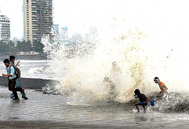 Children enjoy the waves at Worli seaface in Mumbai on a rainy day