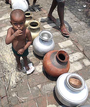 A child waits for water from a non-governmental organisation