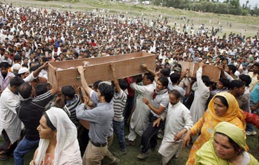 Kashmiri people carry the bodies of two youths after funeral prayers in Srinagar on July 6