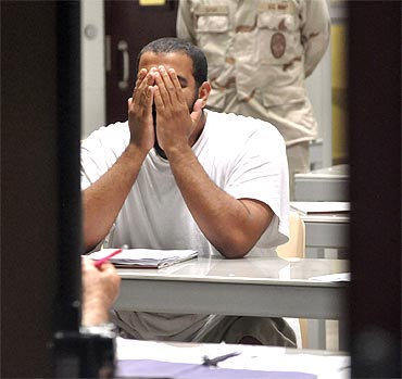 A Guantanamo detainee rubs his face while attending a 'Life Skills' class inside the camp