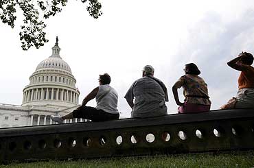 Tourists sit in the shade near the US Capitol in Washington