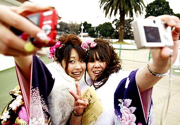 Japanese women take pictures of themselves at Toshimaen amusement park in Tokyo