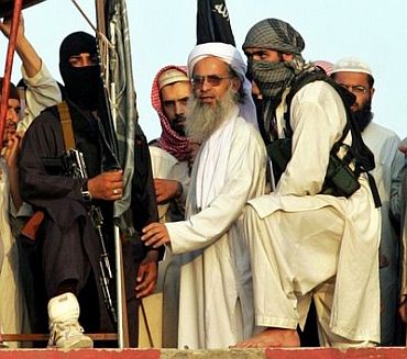 File photo dated March 8, 2007, shows radical Pakistani cleric Abdul Aziz (2-R) surrounded by guards as he stands on a roof of the Lal Masjid or Red Mosque during a protest in Islamabad