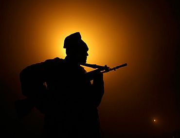 A paramilitary trooper patrols near the fencing at the India-Pakistan border at Suchetgarh, 30km south of Jammu
