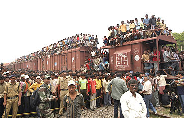 Onlookers stand on top of a goods train at the accident site