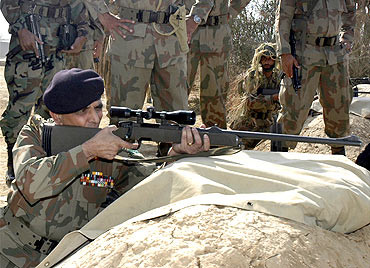 Ashfaq Parvez Kayani fires a sniper rifle during his visit to Tilla Field Firing Ranges November 5, 2007