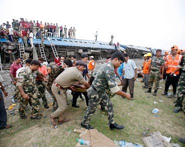 Army personnel carry an injured passenger at the site of the train mishap near Jhargram in May