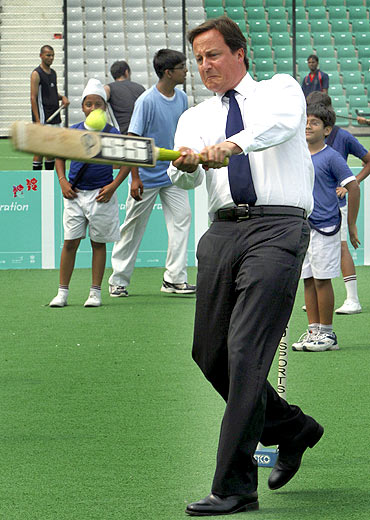 David Cameron plays cricket inside a stadium in New Delhi on Thursday