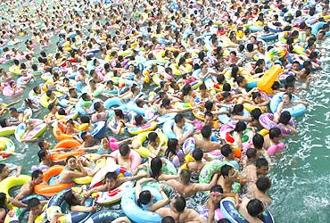 Residents crowd in a swimming pool to escape the summer heat in Suining, Sichuan province