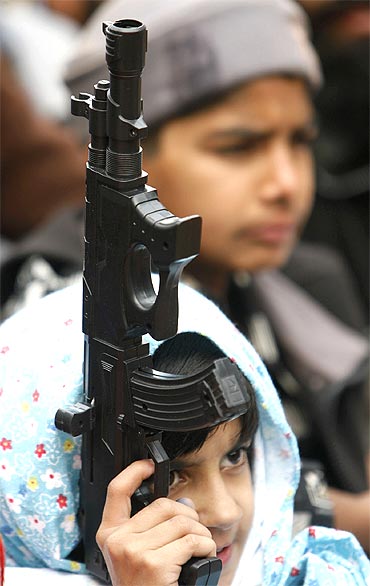 A supporter of the Jamaat-e-Islami holds a toy gun at an anti-India rally