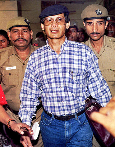 Indian policemen escort Charles Sobhraj as he leaves a New Delhi court in 1995