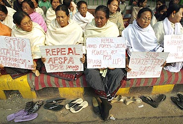 Women hold placards during a protest against the Armed Forces Special Powers Act