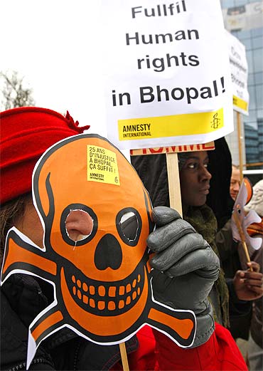 Activists of Amnesty International wear masks representing victims of the Bhopal gas tragedy
