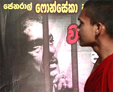 A Buddhist monk walks past a poster of defeated presidential candidate General Sarath Fonseka before the start of a rally against Fonseka's arrest in Colombo on March 8, 2010