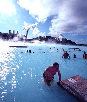 Bathers at the Blue Lagoon hot springs swim in hot mineral waters amid a chilly wind