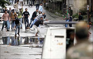 Protesters throw stones and bricks at a police vehicle in Srinagar