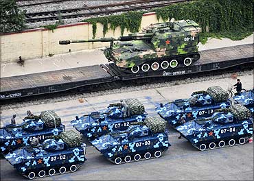 Military vehicles wait in a line in Beijing