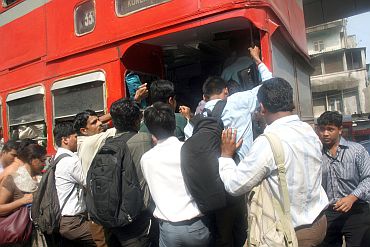 People jostle to enter a crowded public transport bus